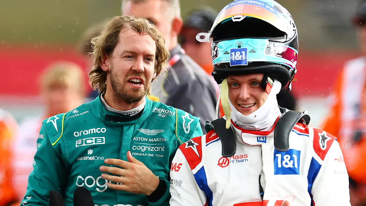 NORTHAMPTON, ENGLAND - JULY 03: Sebastian Vettel of Germany and Aston Martin F1 Team and Mick Schumacher of Germany and Haas F1 talk in parc ferme during the F1 Grand Prix of Great Britain at Silverstone on July 03, 2022 in Northampton, England. (Photo by Mark Thompson/Getty Images)
