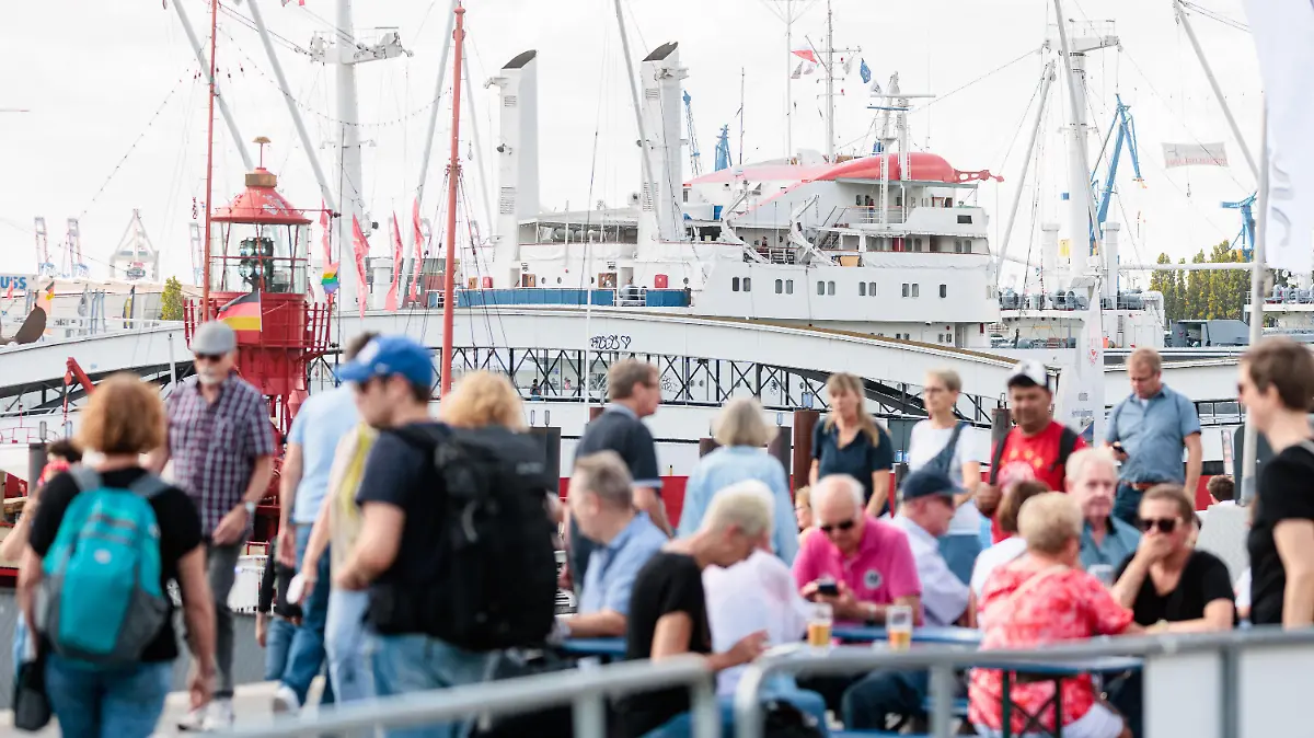 21.08.2022, Hamburg: Besucher der Hochwasserschutzanlage am Baumwall genießen dort bei mildem Sommerwetter den letzte Tag der Cruise Days. Foto: Markus Scholz/dpa +++ dpa-Bildfunk +++