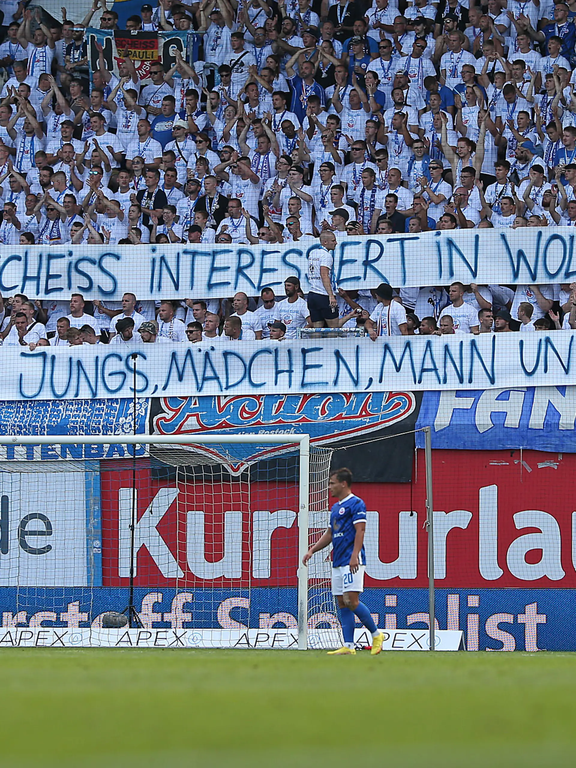 ROSTOCK, GERMANY - AUGUST 21: Supporters of FC Hansa Rostock holding up a sign with a slight jab towards FC St. Pauli and their latest action with the gender asterisk on the last home shirt during the Second Bundesliga match between F.C. Hansa Rostock and FC St. Pauli at Ostseestadion on August 21, 2022 in Rostock, Germany. (Photo by Cathrin Mueller/Getty Images)