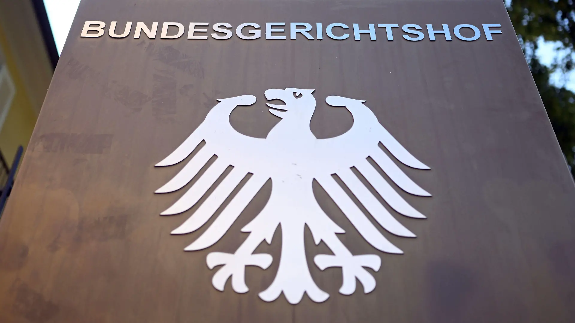 28.07.2022, Baden-Württemberg, Karlsruhe: Ein Hinweisschild mit Bundesadler und dem Schriftzug "Bundesgerichtshof", aufgenommen vor dem Bundesgerichtshof (BGH). Der Dritte Strafsenat verhandelt über die Revisionen von Bundesanwaltschaft, Angeklagten und Nebenklägern, rund drei Jahre nach dem Mord an dem CDU-Politiker Walter Lübcke. Foto: Uli Deck/dpa +++ dpa-Bildfunk +++