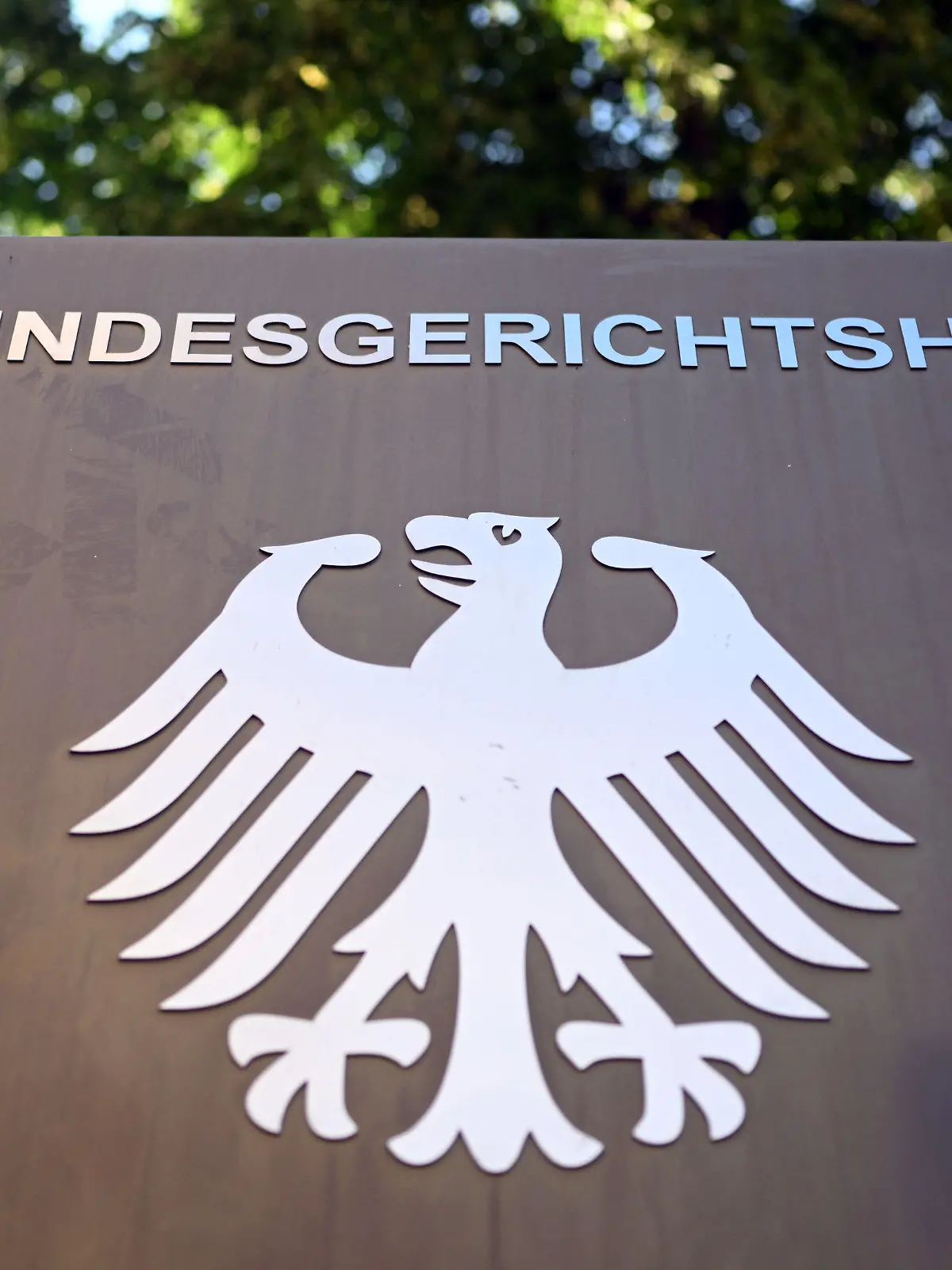 28.07.2022, Baden-Württemberg, Karlsruhe: Ein Hinweisschild mit Bundesadler und dem Schriftzug "Bundesgerichtshof", aufgenommen vor dem Bundesgerichtshof (BGH). Der Dritte Strafsenat verhandelt über die Revisionen von Bundesanwaltschaft, Angeklagten und Nebenklägern, rund drei Jahre nach dem Mord an dem CDU-Politiker Walter Lübcke. Foto: Uli Deck/dpa +++ dpa-Bildfunk +++