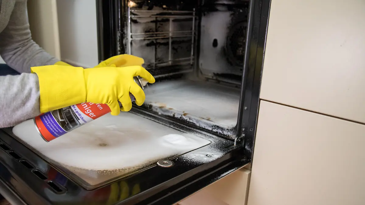 ILLUSTRATION - Eine Frau reinigt am 24.01.2017 in einer Kueche in Hamburg einen Backofen (gestellte Szene). Foto: Christin Klose || Modellfreigabe vorhanden