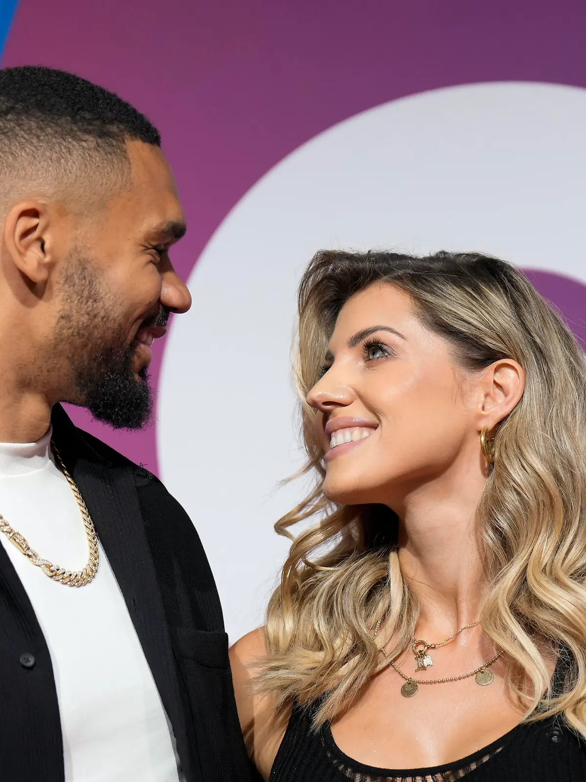 Dominic und Sarah Harrison schauen sich verliebt an auf dem Pink Carpet bei der Messe Glow 2022 in Essen