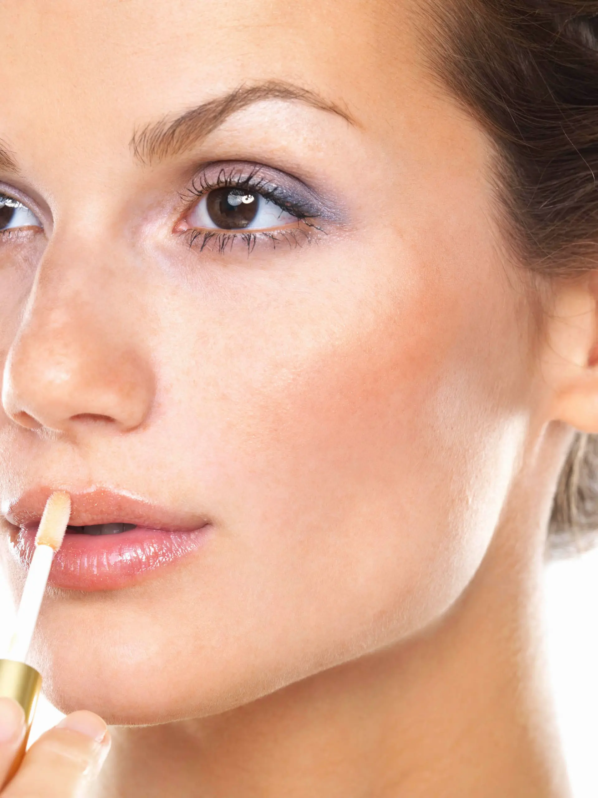 Studio portrait of beautiful woman applying lip gloss, Studiofoto der schoenen Frau, die Lipgloss anwendet Keine Weitergabe an Drittverwerter.