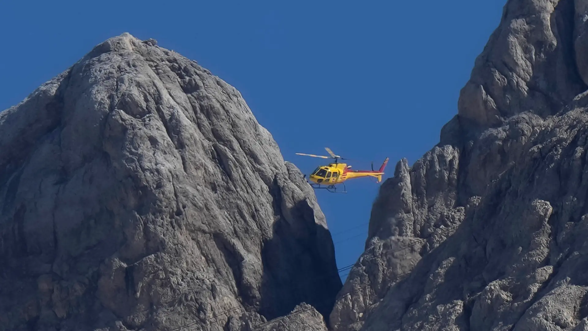 04.07.2022, Italien, Canazei: Ein Rettungshubschrauber überfliegt den Punta-Rocca-Gletscher in der Nähe von Canazei in den italienischen Alpen. Nach dem massiven Gletscherbruch und einer Lawine geht in den Dolomiten die Suche nach weiteren Toten unter erschwerten Bedingungen weiter. Ein siebtes Opfer wurde am 04.07.22 entdeckt, weitere werden befürchtet. Foto: Luca Bruno/AP/dpa +++ dpa-Bildfunk +++