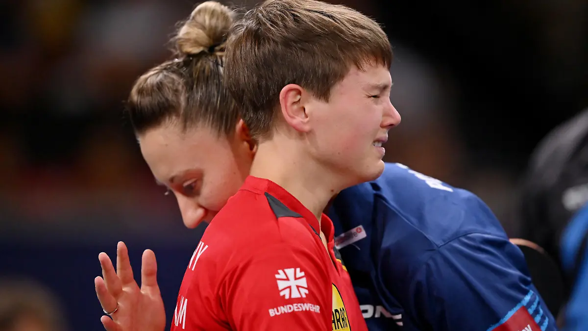 MUNICH, GERMANY - AUGUST 21: Nina Mittelham of Germany reacts upon retiring from the match with an injury, whilst embracing opponent Sofia Polcanova of Austria during the Women's Singles Gold Medal Match on day 11 of the European Championships Munich 2022 at Rudi-Sedlmayer-Halle on August 21, 2022 in Munich, Germany. (Photo by Sebastian Widmann/Getty Images)