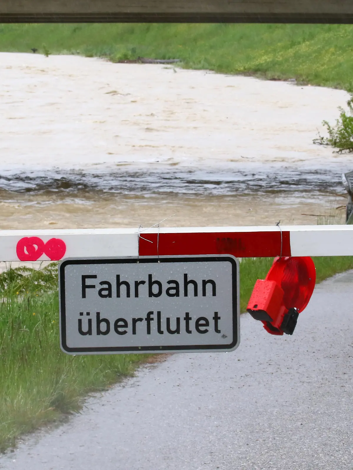 Hochwasser, Bayern, Deutschland 19. August 2022: Hier ein Archivbild von der Ammer in der Gegend um Weilheim /Obb. aus dem Jahr 2019 als Symbolbild, Hochwasser, Starkregen, Wassermassen, Überflutung, Naturkatastrophe, Pegelstand, Überschwemmung, hier mit dem Schild Fahrbahn überflutet