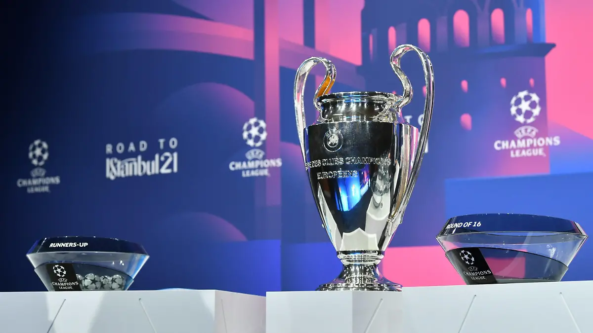 HANDOUT - 14.12.2020, Schweiz, Nyon: Fußball: UEFA Champions League, Auslosung - K.o.-Runde, Achtelfinale. Der Champions-League-Pokal steht neben den Lostöpfen auf einem Podest. Foto: Harold Cunningham/UEFA/dpa - ACHTUNG: Nur zur redaktionellen Verwendung im Zusammenhang mit der aktuellen Berichterstattung und nur mit vollständiger Nennung des vorstehenden Credits +++ dpa-Bildfunk +++