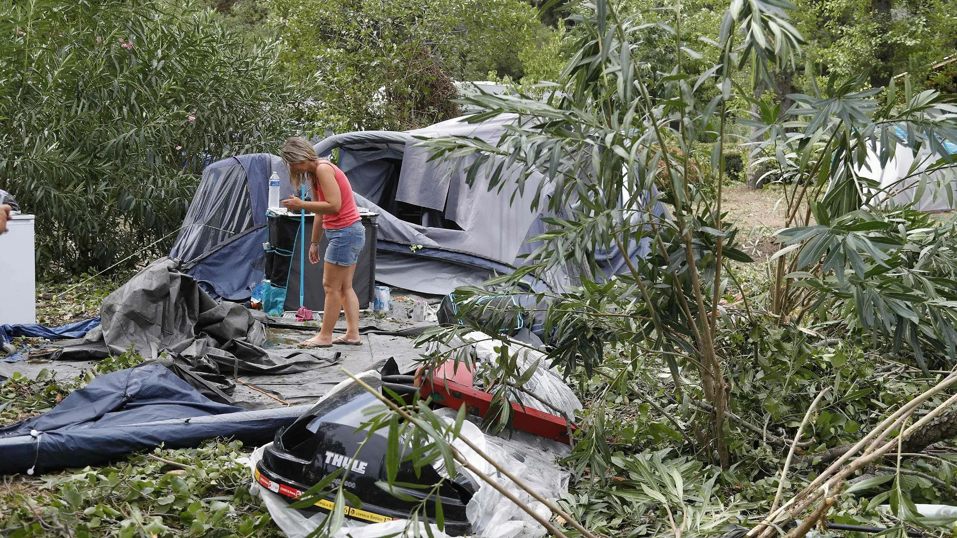 dpatopbilder - 18.08.2022, Frankreich, Coggia: Eine Frau packt die Reste der zerstörten Zelte und anderen Gegenstände auf dem Campingplatz Sagone ein, wo ein Baum während eines Sturms auf einen Bungalow stürzte und eine Person tötete. Bei heftigen Unwettern auf der französischen Mittelmeerinsel Korsika sind mehrere Menschen gestorben. Foto: Pascal Pochard-Casabianca/AFP/dpa +++ dpa-Bildfunk +++