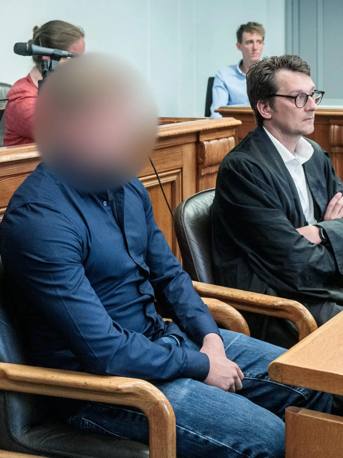 18.08.2022, Schleswig-Holstein, Kiel: Der Angeklagte (Ml), ein 26-jähriger Mann, sitzt neben seinem Anwalt Martin Schaar (Mr) in einem Gerichtssaal des Kieler Landgerichts. Er soll im Januar 2021 unter Einfluss von Drogen und ohne Fahrerlaubnis mit einem Auto bei überhöhter Geschwindigkeit in einer langgezogenen Rechtskurve von der Fahrbahn abgekommen sein und eine Fußgängergruppe auf dem Gehweg erfasst haben. Dabei starben drei Menschen. Foto: Markus Scholz/dpa +++ dpa-Bildfunk +++
