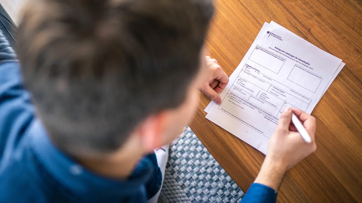 HANDOUT - 03.03.2022, ---: ILLUSTRATION - Ein "Antrag auf Leistung für Gewaltopfer" des Bundesministerium für Arbeit und Soziales wird ausgefühlt. Die staatliche Hilfe für Opfer von Gewalt ist nach einer Erhebung des Weißen Rings in Deutschland auf einen Tiefstand gesunken. (zu dpa "Weißer Ring: Staatliche Hilfe für Gewaltopfer auf Tiefstand") Foto: Hauke-Christian Dittrich/Weißer Ring/dpa - ACHTUNG: Nur zur redaktionellen Verwendung im Zusammenhang mit einer Berichterstattung über den Weißen Ring und nur mit vollständiger Nennung des vorstehenden Credits +++ dpa-Bildfunk +++