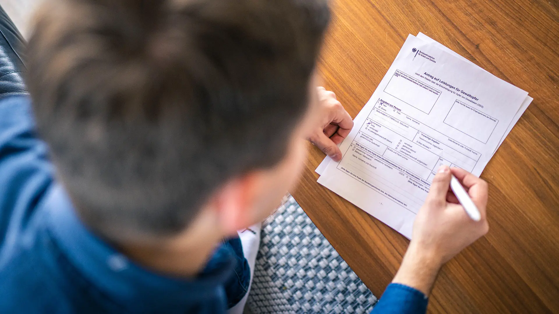 HANDOUT - 03.03.2022, ---: ILLUSTRATION - Ein "Antrag auf Leistung für Gewaltopfer" des Bundesministerium für Arbeit und Soziales wird ausgefühlt. Die staatliche Hilfe für Opfer von Gewalt ist nach einer Erhebung des Weißen Rings in Deutschland auf einen Tiefstand gesunken. (zu dpa "Weißer Ring: Staatliche Hilfe für Gewaltopfer auf Tiefstand") Foto: Hauke-Christian Dittrich/Weißer Ring/dpa - ACHTUNG: Nur zur redaktionellen Verwendung im Zusammenhang mit einer Berichterstattung über den Weißen Ring und nur mit vollständiger Nennung des vorstehenden Credits +++ dpa-Bildfunk +++