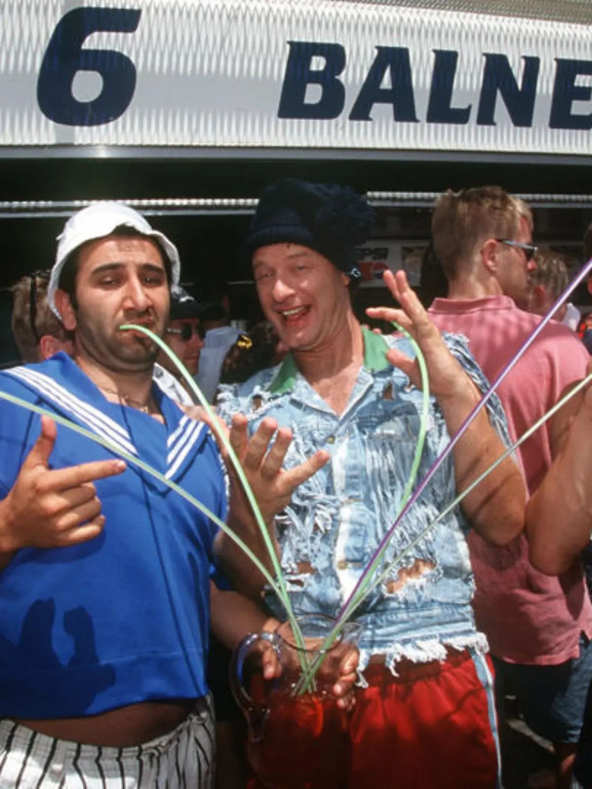 Als Mario blödelt Hilmi Sözer (2.v.l) mit Tom Gerhardt (2.v.r) als Tommie zwischen zwei Muskelmännern bei den Dreharbeiten im Juni 1997 vor der berühmt-berüchtigten Kneipe "Ballermann 6" in El Arenal auf Mallorca. Nach dem Erfolg seines ersten Kinofilms "Voll normaaal" produzierte Tom Gerhardt seine zweite Kinokomödie "Ballermann 6". Die Dreharbeiten starteten im Mai 1997 auf Mallorca. Dort fallen die "größten Verlierer Deutschlands", Tommie (Tom Gerhardt) und Mario (Hilmi Sözer) ein und sorgen für kunterbuntes Chaos... Gerhardt schrieb das Drehbuch und ist erstmals auch als Co-Regisseur neben Gernot Roll tätig. Roll, der sich als Kameramann einen Namen gemacht hat, führt zum ersten Mal Regie.