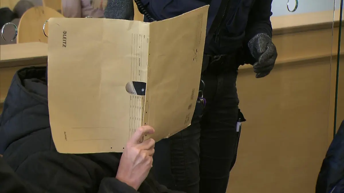 Am letzten Prozesstag verhüllt die Angeklagte ihr Gesicht mit einem Aktenordner.