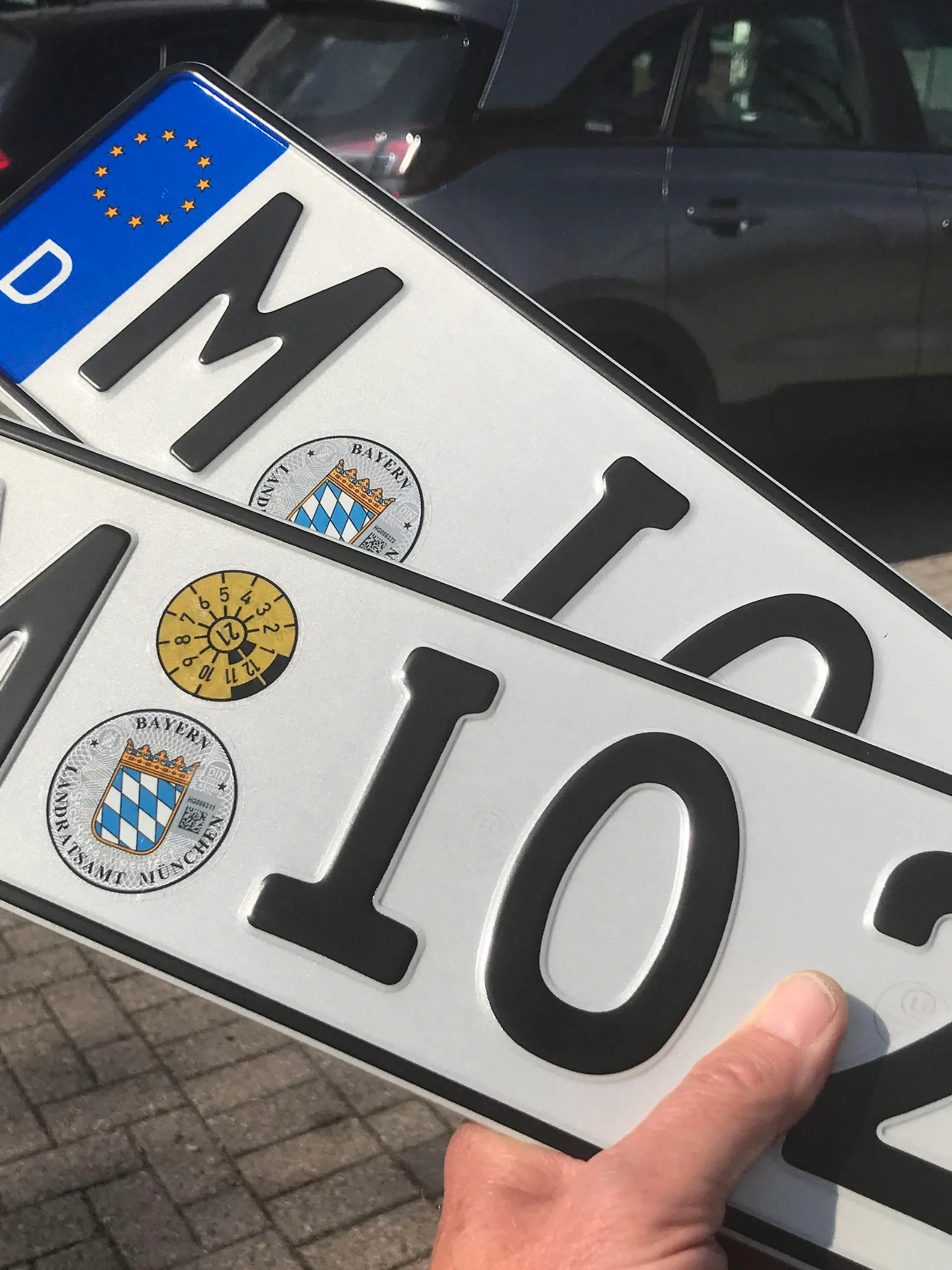 Zwei Autokennzeichen mit TUEV Plakette nach Erhalt bei der KFZ Zulassungstelle Haar im Landkreis Muenchen