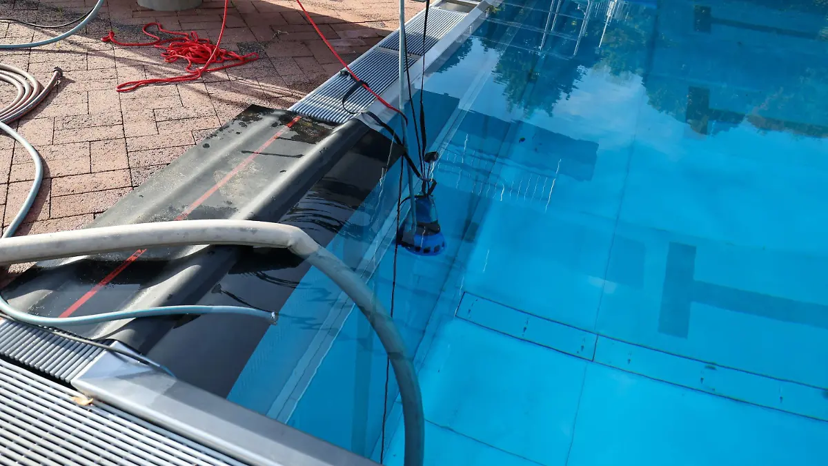 12.09.2022, Hessen, Bad Schwalbach: Eine Tauchpumpe der Feuerwehr pumpt Wasser aus dem Becken. Das Schwimmbad in Bad Schwalbach lädt alle dazu ein, sich nach dem Ende der Saison gebrauchtes Wasser zum Gießen abzuholen. Es gibt etwa 800 000 Liter Wasser zu verschenken. Das Bad hatte am 4. September geschlossen, danach dauerte es acht Tage bis das Chlor zerfällt. Foto: Jörg Halisch/dpa +++ dpa-Bildfunk +++