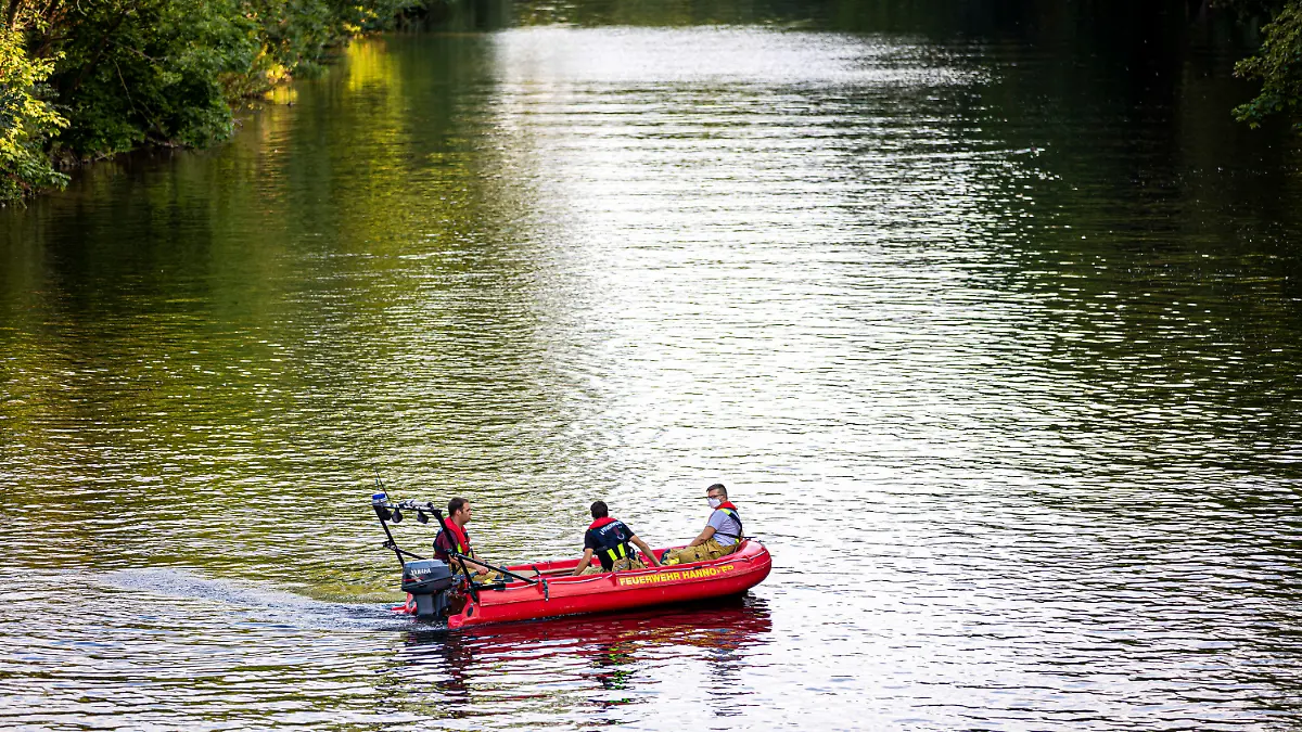 16.08.2022, Niedersachsen, Hannover: Einsatzkräfte der Feuerwehr suchen mit einem Boot auf der Ihme, einem Nebenfluss der Leine, nach einer vermissten Person. In Hannover ist am Dienstagabend (16.08.2022) ein junger Mann in der Ihme ertrunken. Taucher bargen den Mann nach etwa einer Stunde unter Wasser aus dem Fluss, wie die Feuerwehr mitteilte. Foto: Moritz Frankenberg/dpa +++ dpa-Bildfunk +++