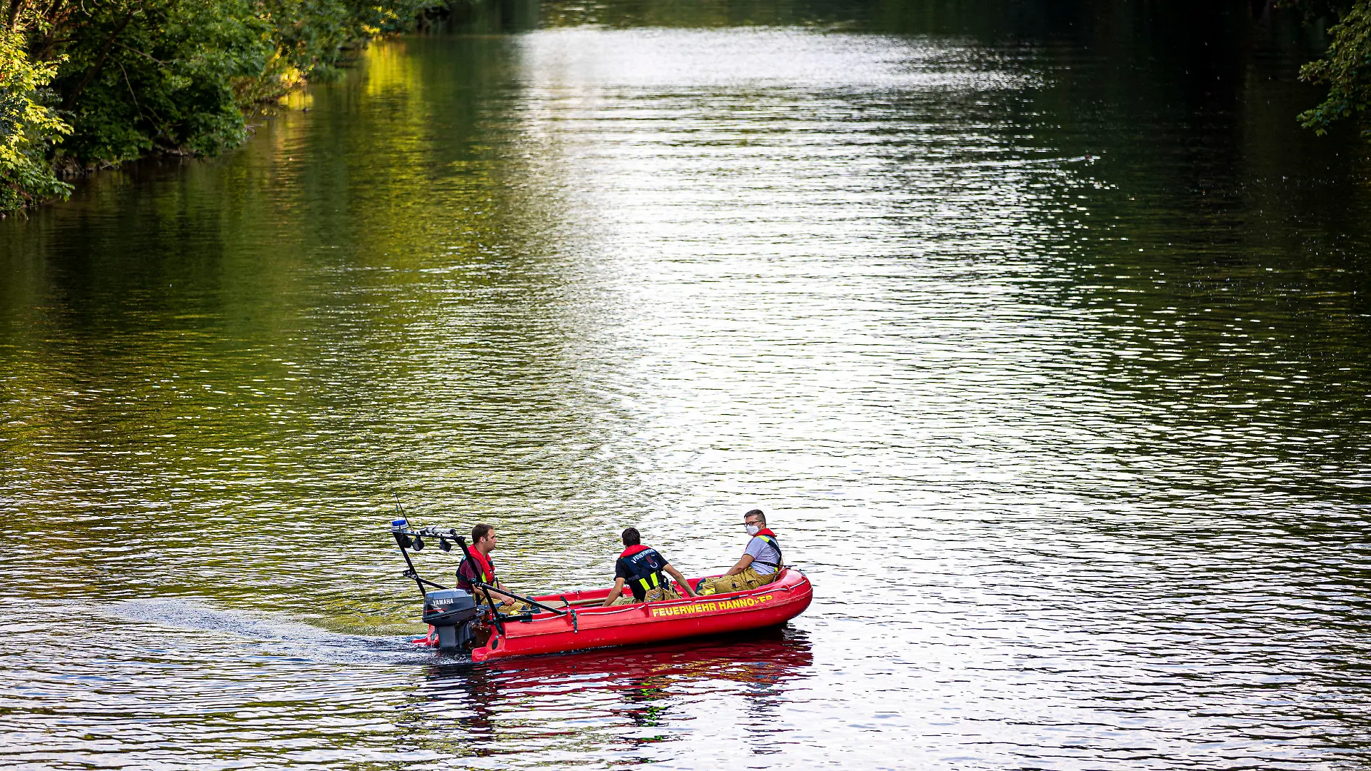 16.08.2022, Niedersachsen, Hannover: Einsatzkräfte der Feuerwehr suchen mit einem Boot auf der Ihme, einem Nebenfluss der Leine, nach einer vermissten Person. In Hannover ist am Dienstagabend (16.08.2022) ein junger Mann in der Ihme ertrunken. Taucher bargen den Mann nach etwa einer Stunde unter Wasser aus dem Fluss, wie die Feuerwehr mitteilte. Foto: Moritz Frankenberg/dpa +++ dpa-Bildfunk +++