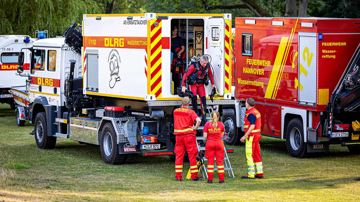 16.08.2022, Niedersachsen, Hannover: Einsatzkräfte der Deutschen Lebens-Rettungs-Gesellschaft (DLRG) bereiten sich an der Ihme, einem Nebenfluss der Leine, auf ihren Einsatz vor. In Hannover ist am Dienstagabend (16.08.2022) ein junger Mann in der Ihme ertrunken. Taucher bargen den Mann nach etwa einer Stunde unter Wasser aus dem Fluss, wie die Feuerwehr mitteilte. Foto: Moritz Frankenberg/dpa +++ dpa-Bildfunk +++
