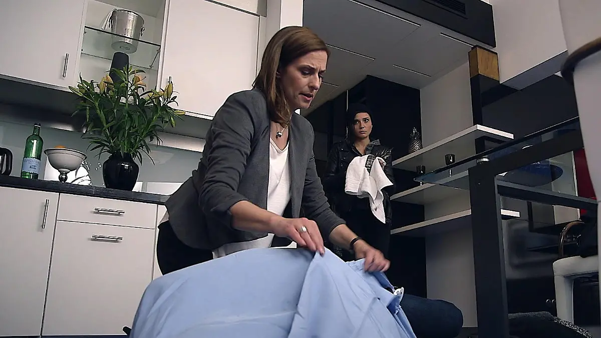 Katrin bedeckt die Leiche mit einer Decke, Anni säubert die Ananas