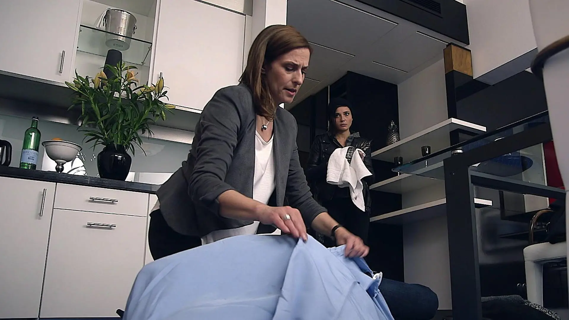 Katrin bedeckt die Leiche mit einer Decke, Anni säubert die Ananas