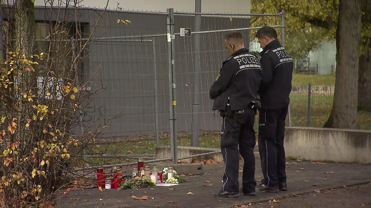 Polizeibeamte stehen vor einer Trauerstelle.