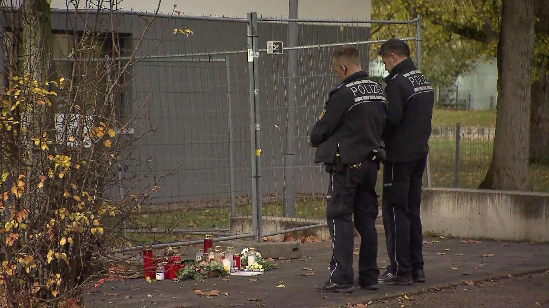 Polizeibeamte stehen vor einer Trauerstelle.