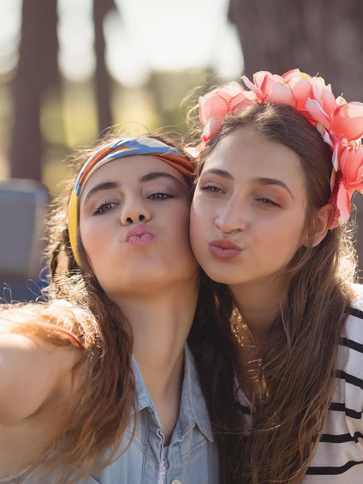 Close up of women puckering while clicking selfie in forest || Modellfreigabe vorhanden