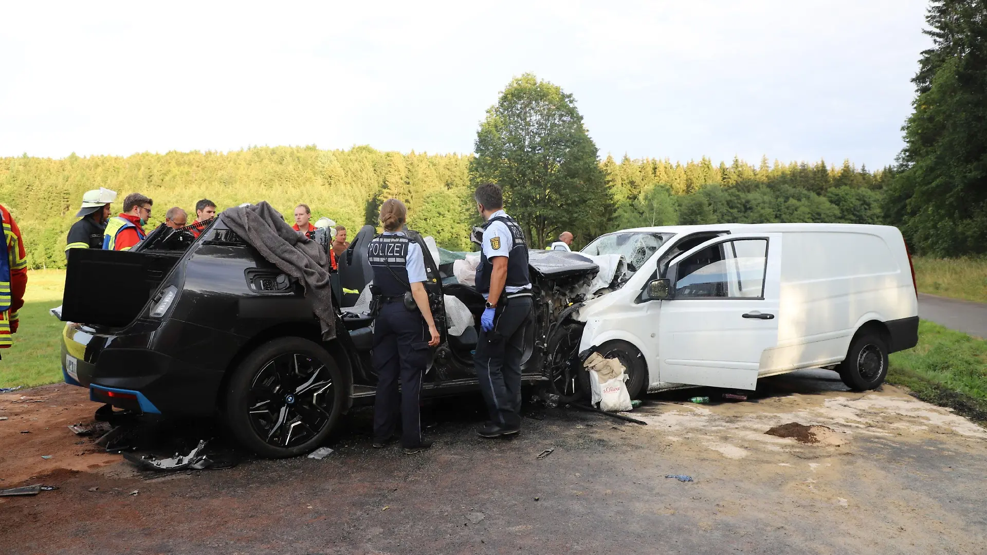 15.08.2022, Baden-Württemberg, Römerstein: Rettungskräfte stehen an zerstörten Fahrzeugen. Bei einem schweren Verkehrsunfall auf der B28 bei Römerstein (Landkreis Reutlingen) ist nach Polizeiangaben mindestens ein Mensch ums Leben gekommen. Mehrere Personen seien bei dem Unfall am Montag in der Nähe der Ortschaft Zainingen schwer verletzt worden. Foto: Kaczor/SDMG/dpa +++ dpa-Bildfunk +++