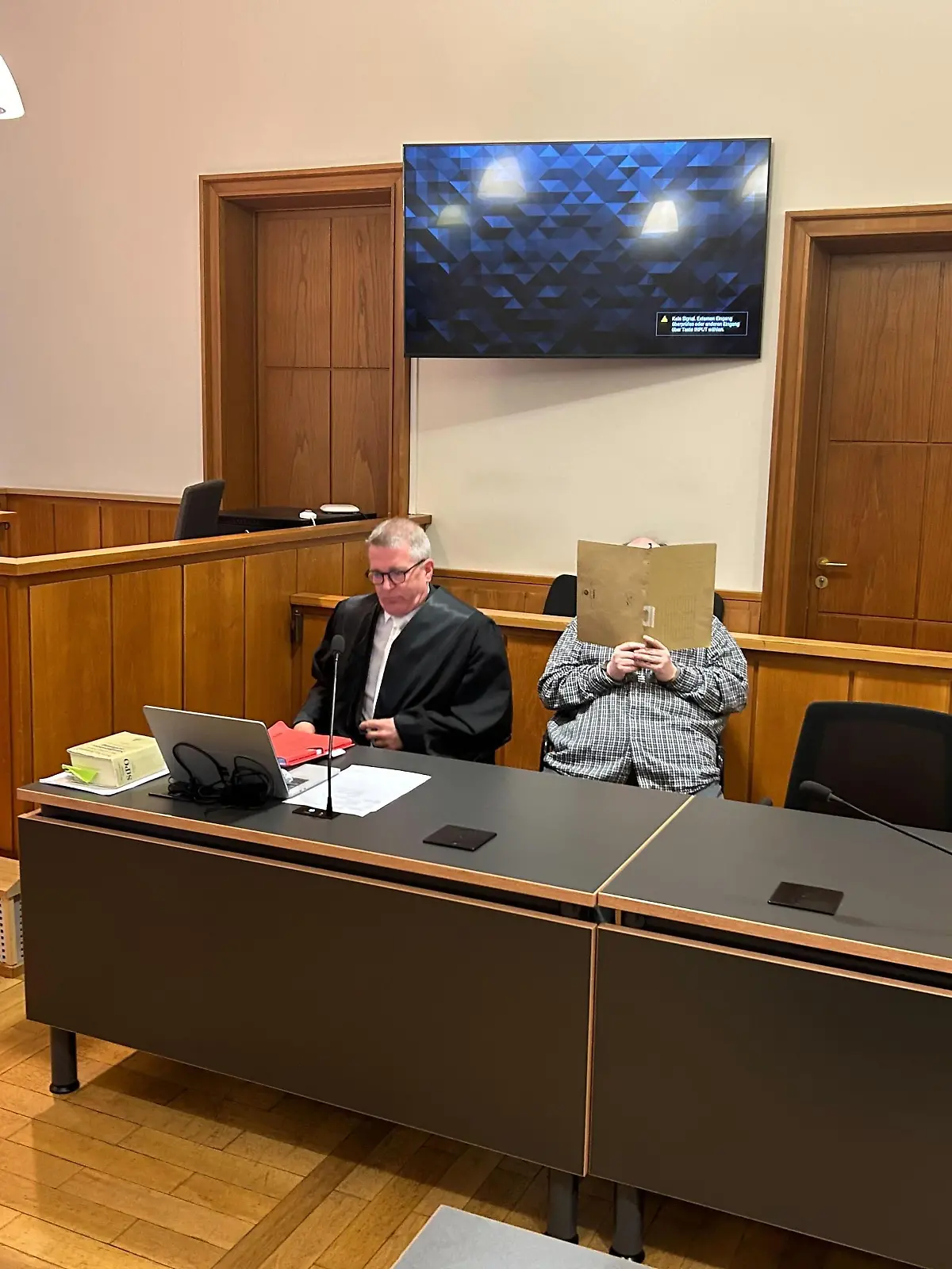 Der Angeklagte im Gerichtssaal, der Prozess findet unter Ausschluss der Öffentlichkeit an.