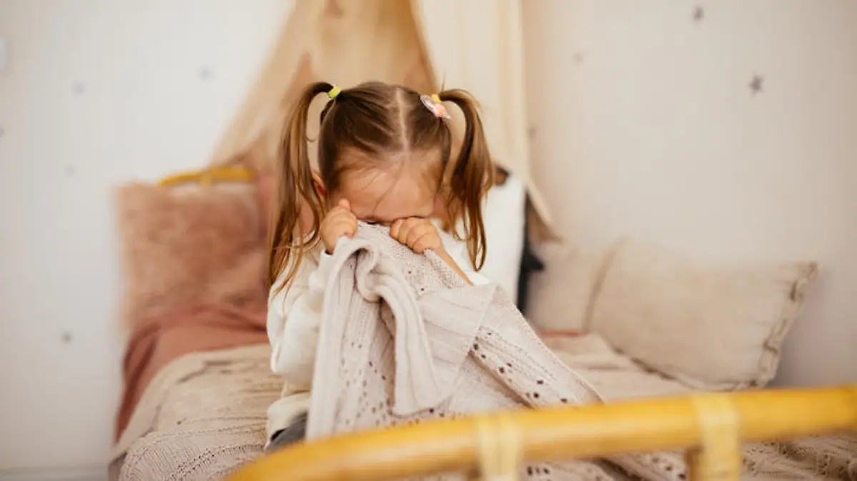 Portrait of unhappy small girl indoors, crying.