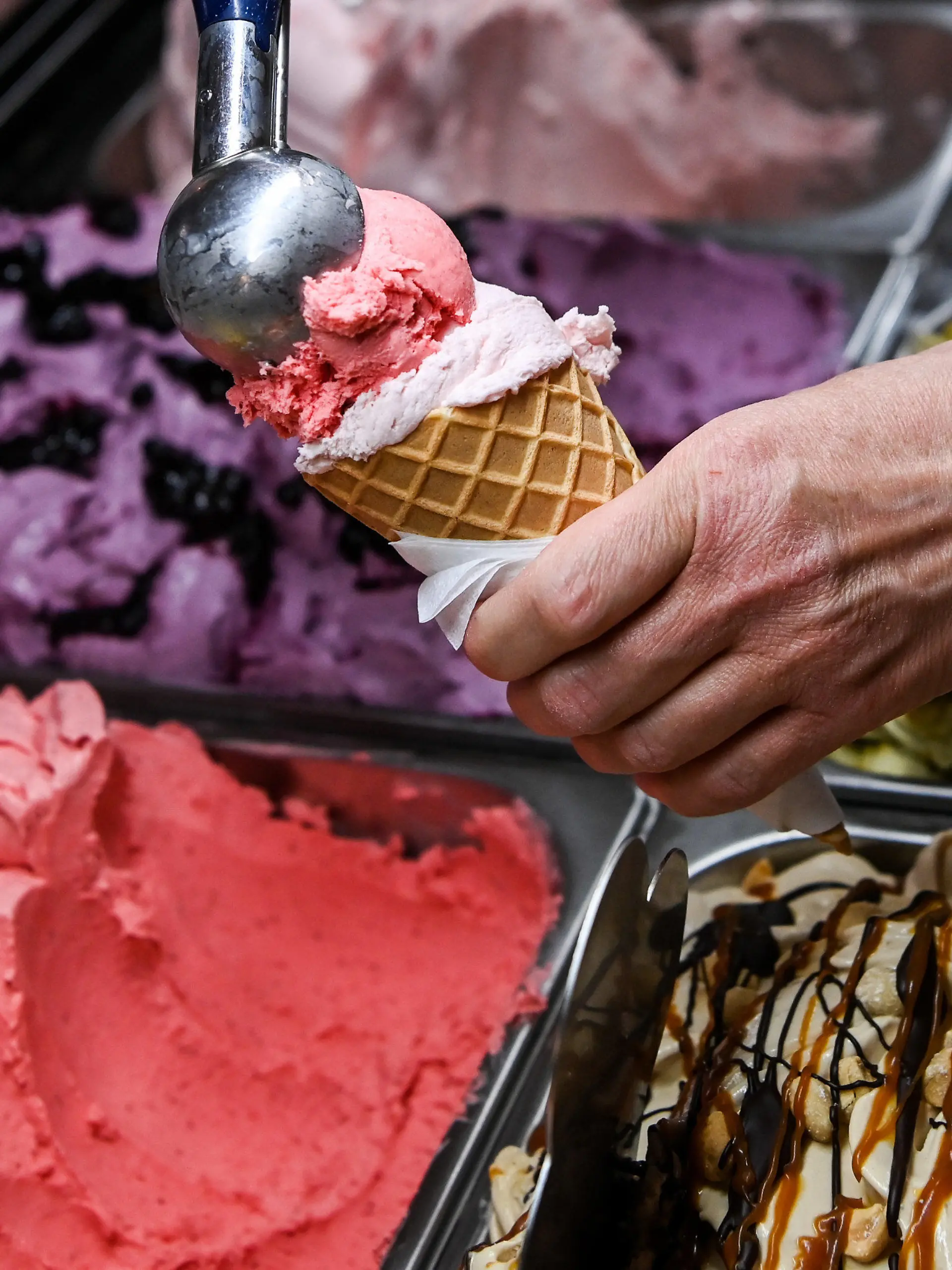 ARCHIV - 24.05.2022, Berlin: Eine Kugel Erdbeereis wird in einer Eisdiele auf eine weitere Kugel in einem Waffelhörnchen gesetzt. (zu dpa: ««Gelato Week Berlin» - Spezielle Eissorten zum Probieren») Foto: Jens Kalaene/dpa +++ dpa-Bildfunk +++