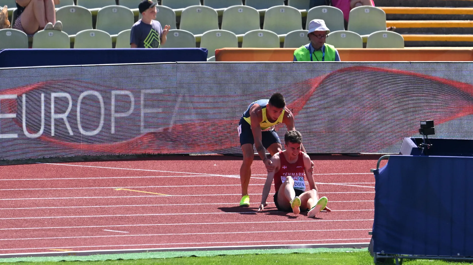 MUNICH, GERMANY - AUGUST 16: Nahuel Carabana of Andorra stops to help injured Axel Vang Christensen of Denmark in the Men's 3000m Steeplechase Round 1 - Heat 1 during the Athletics competition on day 6 of the European Championships Munich 2022 at Olympiapark on August 16, 2022 in Munich, Germany. (Photo by Matthias Hangst/Getty Images)