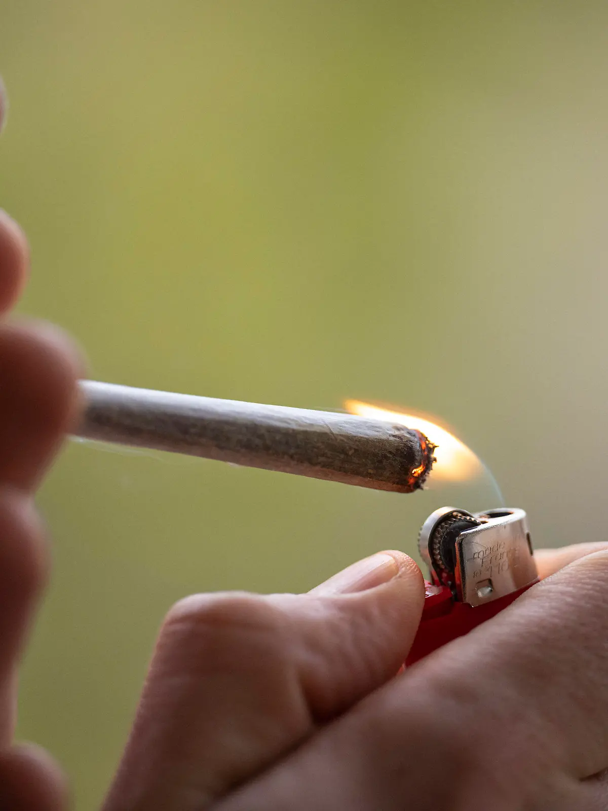 ARCHIV - 15.04.2023, Berlin: Ein Mann zündet sich einen Joint an. Als erstes Bundesland hat Bayern einen Bußgeld-Katalog für Verstöße gegen das Cannabisgesetz beschlossen. Empfindliche Strafzahlungen drohen hier. Wie wollen die anderen Bundesländer Cannabis-Verstöße künftig ahnden? (zu dpa: «Bei Cannabis-Bußgeldern zeichnet sich ein Flickenteppich ab») Foto: Hannes P Albert/dpa +++ dpa-Bildfunk +++