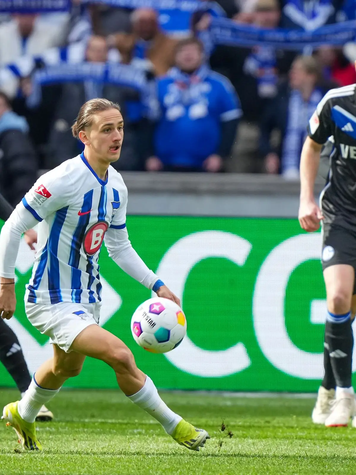 Herthas Michal Karbownik (M) nimmt den Ball vor Simon Terodde (r) von Schalke an.