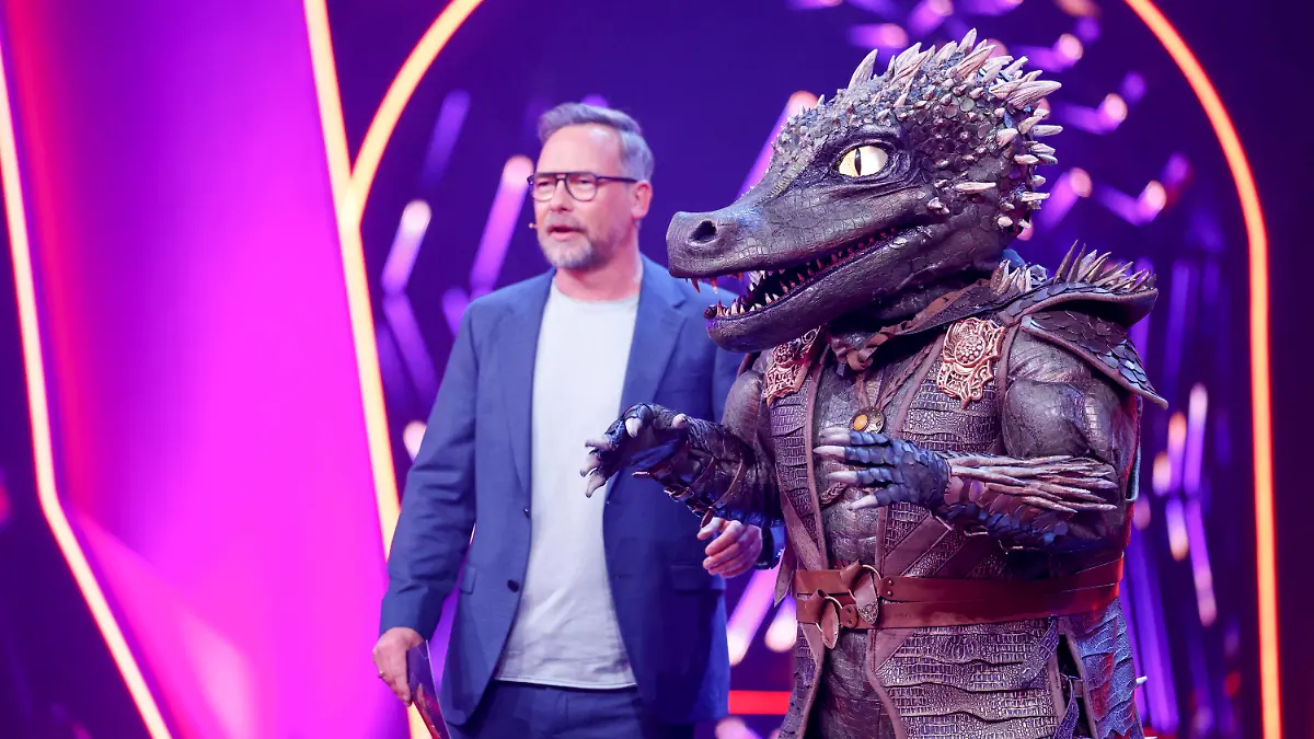 06.04.2024, Nordrhein-Westfalen, Köln: Matthias Opdenhövel, Moderator, steht neben der Figur «Das Krokodil» in der Prosieben-Show «The Masked Singer» auf der Bühne. Foto: Thomas Banneyer/dpa +++ dpa-Bildfunk +++