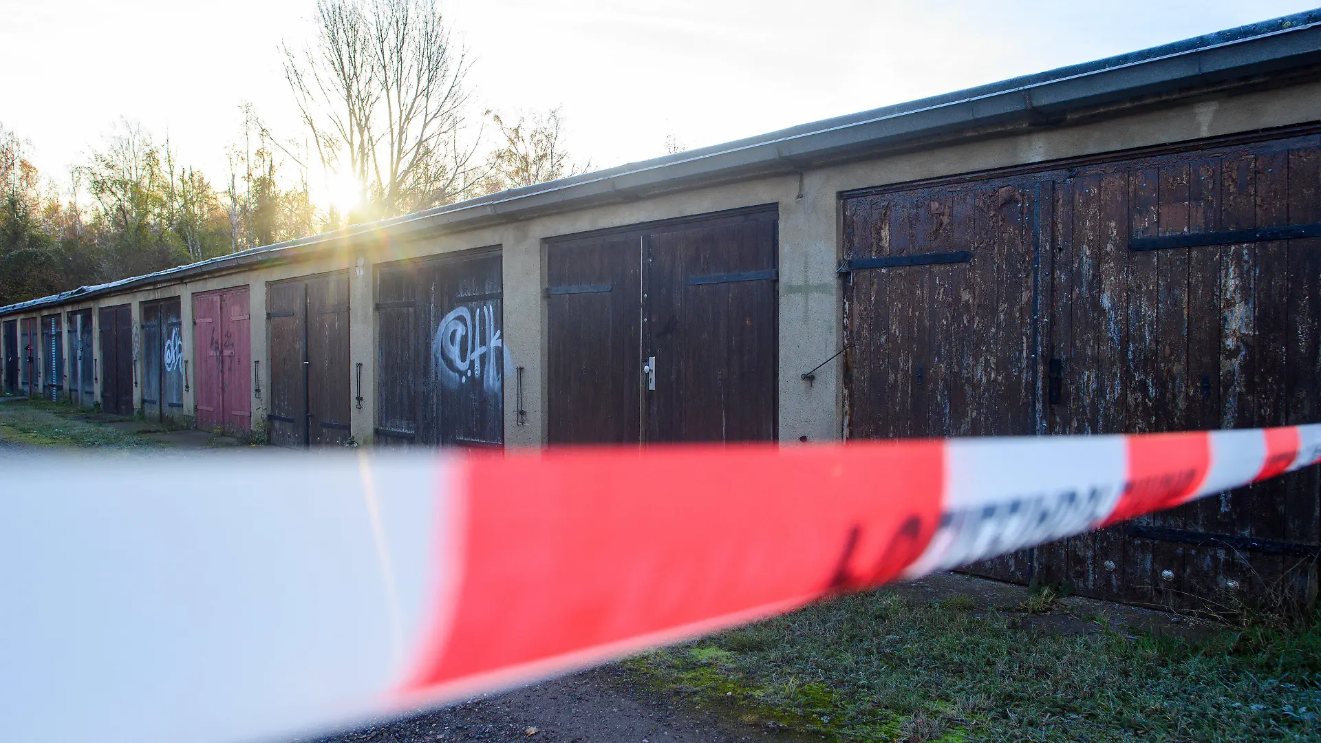 11.11.2021, Sachsen-Anhalt, Aschersleben: Absperrband der Polizei sperrt einen Teil eines Garagenkomplexes ab. Dort war die Leiche von einer 14-Jähriger gefunden worden die seit Tagen als vermisst galt. Foto: Klaus-Dietmar Gabbert/dpa-Zentralbild/dpa +++ dpa-Bildfunk +++