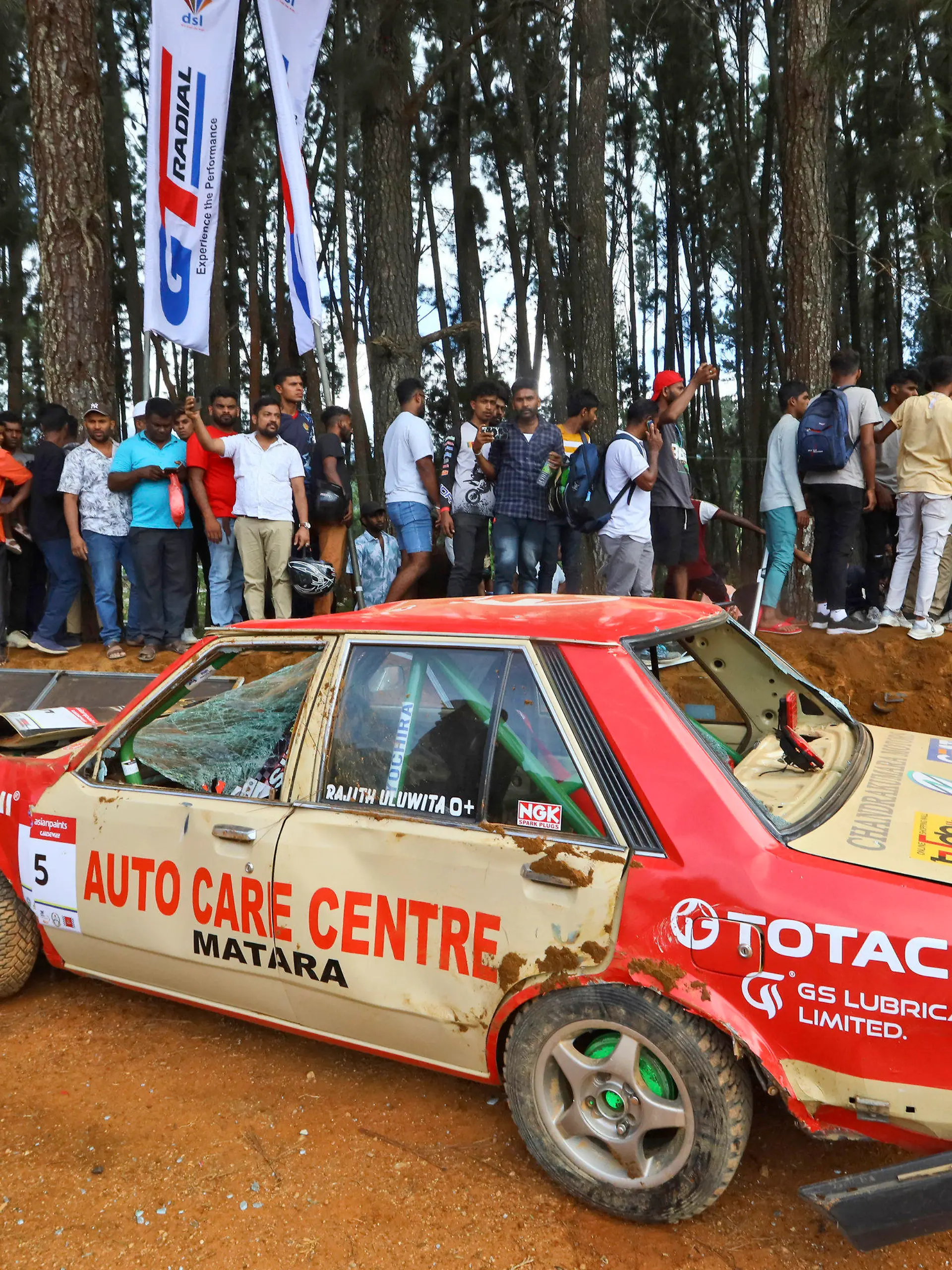 People gather around a car that had crashed into the spectators during the Fox Hill Supercross, a motor racing event organized by the Sri Lanka's army, in Diyatalawa, Sri Lanka, Sunday, April 21, 2024. (AP Photo/STR)