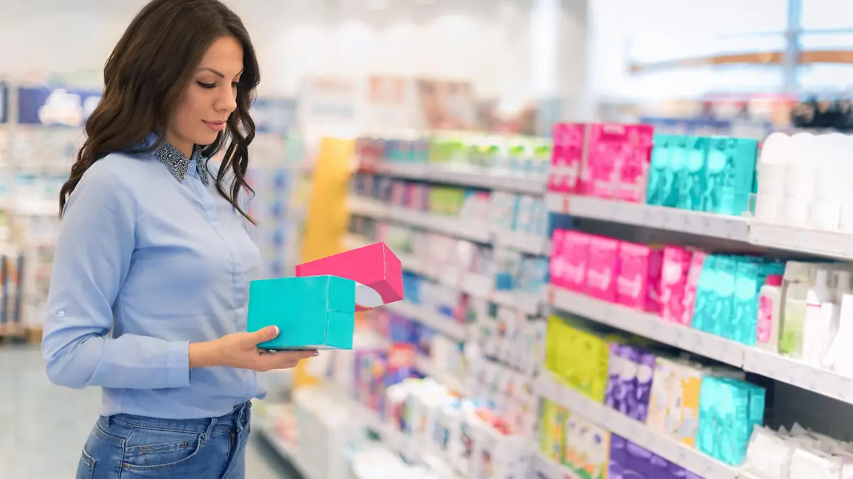Frau kauft Menstruationsartikel in Drogeriemarkt.