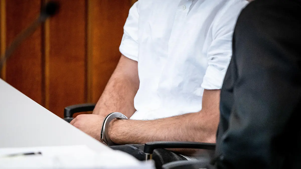 ARCHIV - 15.08.2023, Baden-Württemberg, Heilbronn: Der Angeklagte sitzt mit Handschellen in einem Gerichtssaal des Landgerichts Heilbronn auf seinem Platz. Der wegen Mordes angeklagte 21-jährige Mann verursachte mit einem Fahrzeug in der Heilbronner Innenstadt aufgrund von deutlich überhöhter Geschwindigkeit einen schweren Unfall, bei dem ein 42-jähriger Mann sein Leben verlor. (zu dpa: «Mord am Steuer? Raser-Prozess könnte vor dem Abschluss stehen») Foto: Christoph Schmidt/dpa +++ dpa-Bildfunk +++