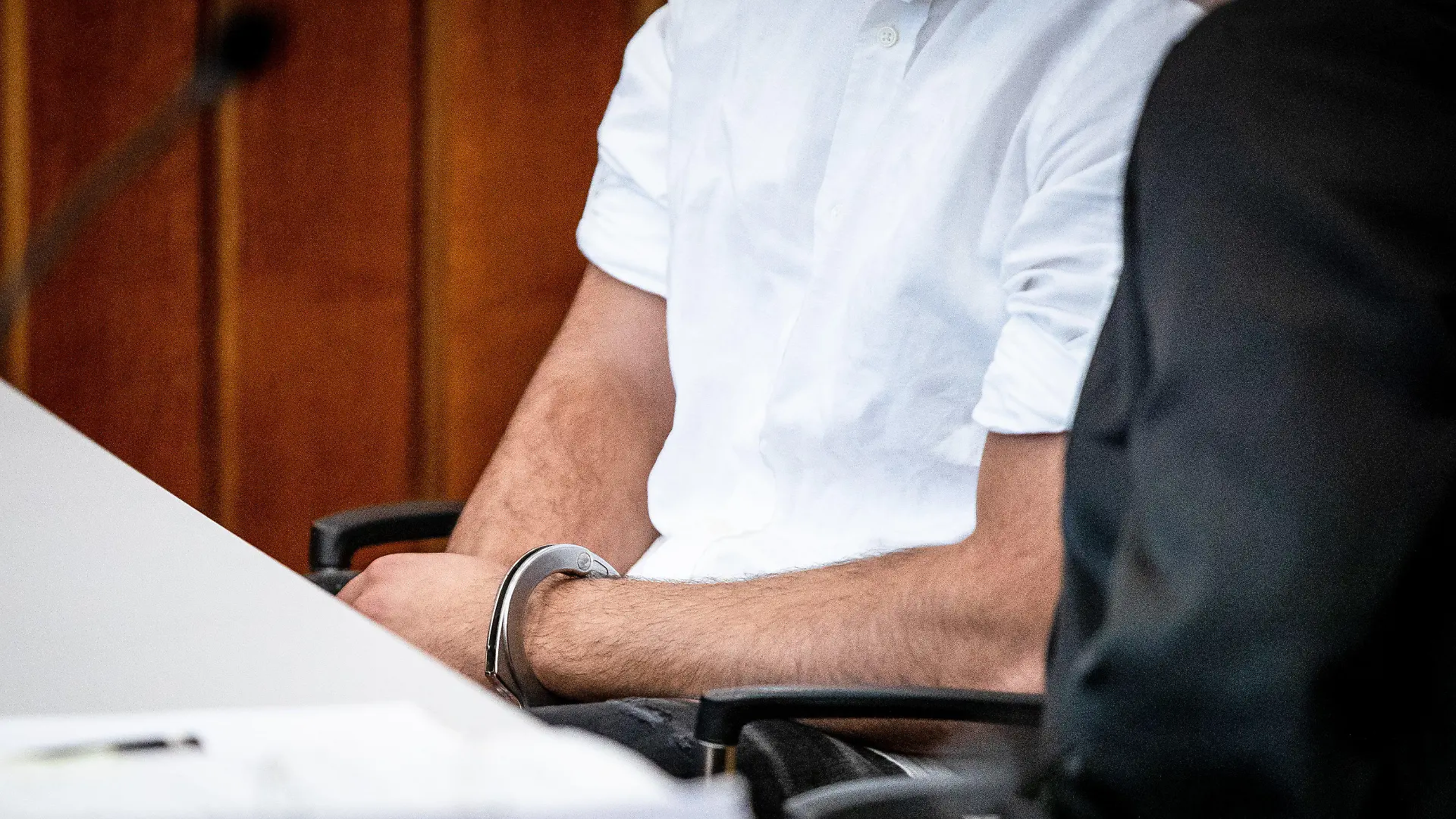 ARCHIV - 15.08.2023, Baden-Württemberg, Heilbronn: Der Angeklagte sitzt mit Handschellen in einem Gerichtssaal des Landgerichts Heilbronn auf seinem Platz. Der wegen Mordes angeklagte 21-jährige Mann verursachte mit einem Fahrzeug in der Heilbronner Innenstadt aufgrund von deutlich überhöhter Geschwindigkeit einen schweren Unfall, bei dem ein 42-jähriger Mann sein Leben verlor. (zu dpa: «Mord am Steuer? Raser-Prozess könnte vor dem Abschluss stehen») Foto: Christoph Schmidt/dpa +++ dpa-Bildfunk +++