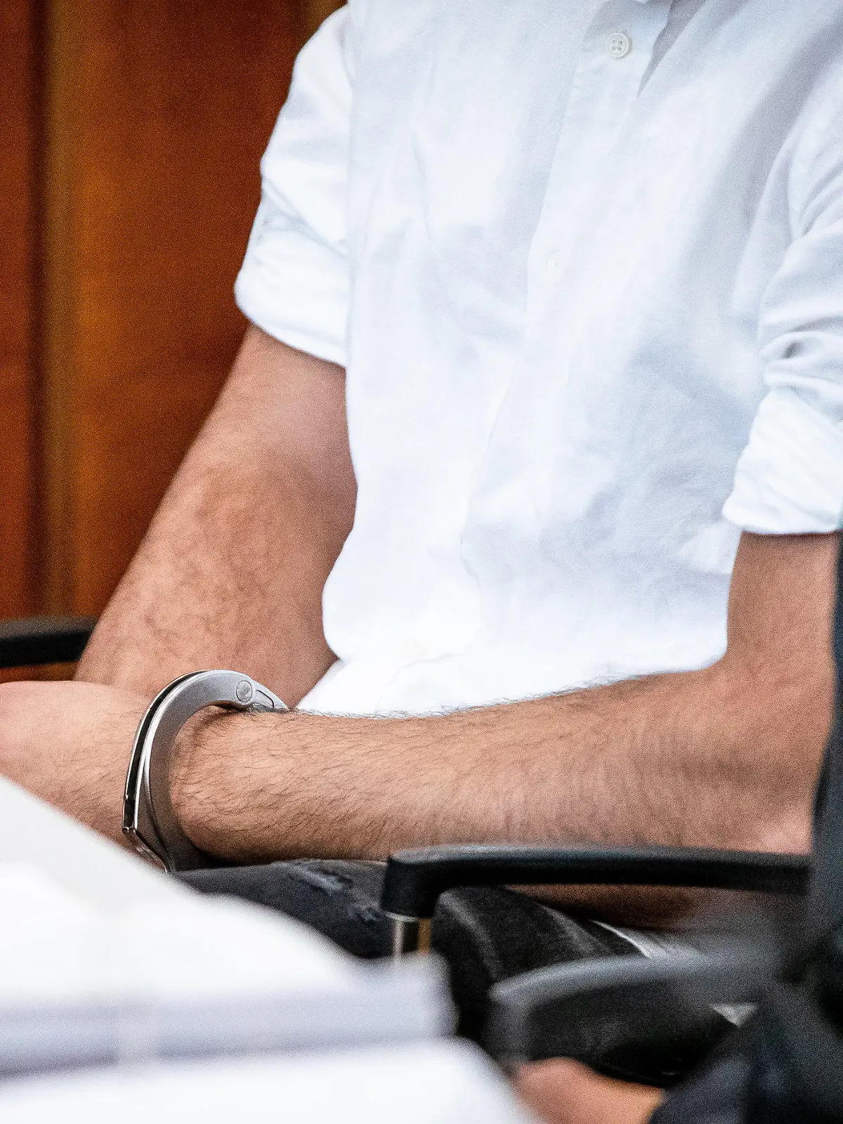 ARCHIV - 15.08.2023, Baden-Württemberg, Heilbronn: Der Angeklagte sitzt mit Handschellen in einem Gerichtssaal des Landgerichts Heilbronn auf seinem Platz. Der wegen Mordes angeklagte 21-jährige Mann verursachte mit einem Fahrzeug in der Heilbronner Innenstadt aufgrund von deutlich überhöhter Geschwindigkeit einen schweren Unfall, bei dem ein 42-jähriger Mann sein Leben verlor. (zu dpa: «Mord am Steuer? Raser-Prozess könnte vor dem Abschluss stehen») Foto: Christoph Schmidt/dpa +++ dpa-Bildfunk +++
