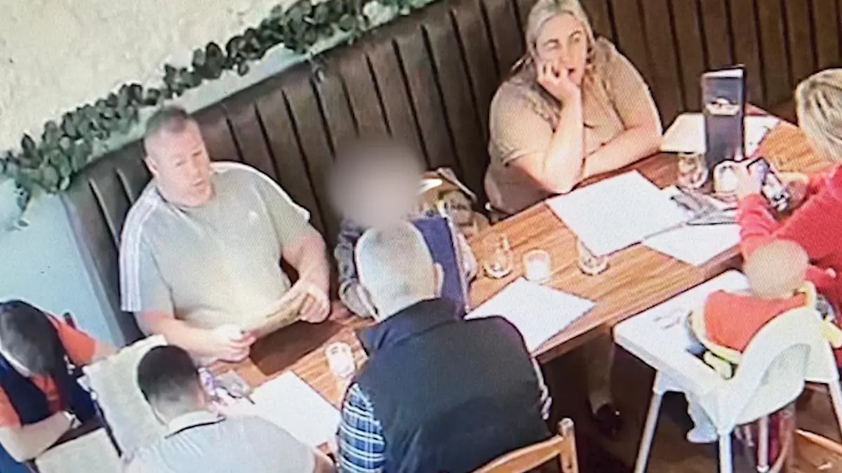 Eine Familie sitzt in einem Restaurant am gedeckten Tisch.