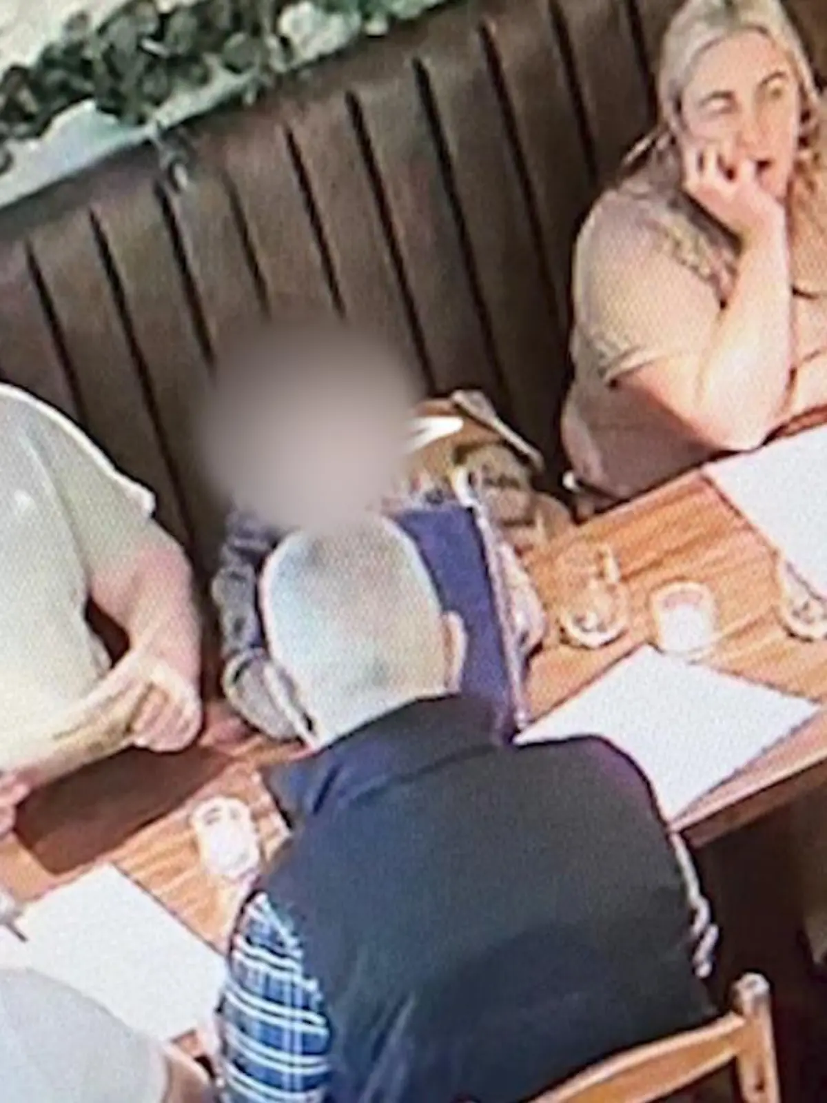 Eine Familie sitzt in einem Restaurant am gedeckten Tisch.