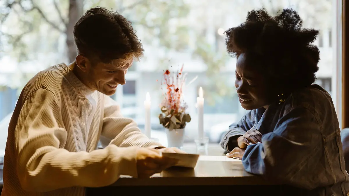 Boyfriend and girlfriend reading menu card while sitting at bar Germany, Berlin, model released, property released Copyright: xMaskotx , MA108408 MA108408