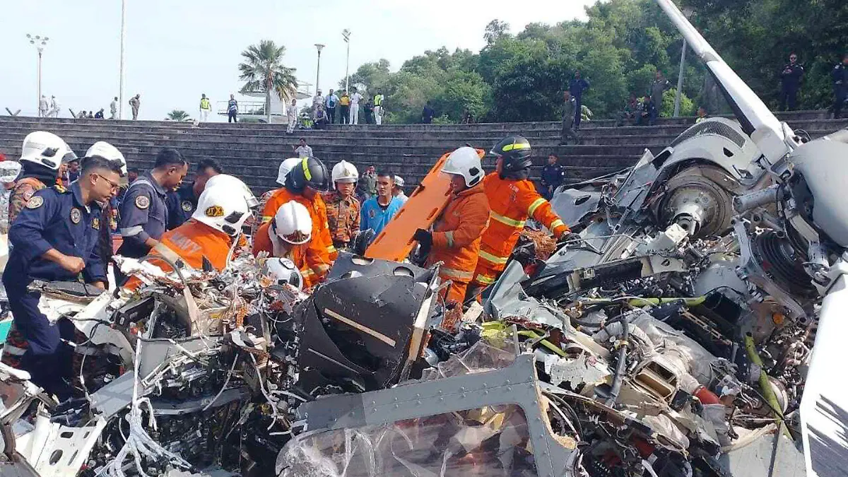 In this photo released by Fire & Rescue Department of Malaysia, fire and rescue department inspect the crash site of two helicopter in Lumur, Perak state, Monday, April 23, 2024. Malaysia's navy says two military helicopters collided and crashed during a training session, killing all 10 people on board. (Terence Tan/Ministry of Communications and Information via AP)