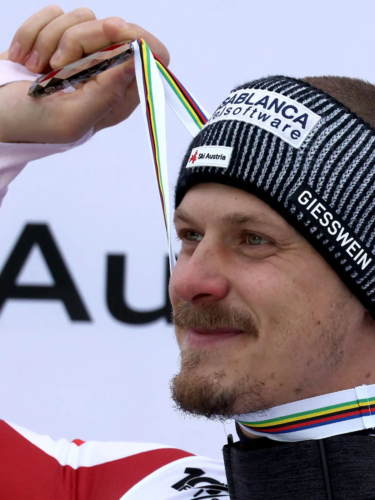 Austria's Manuel Feller holds up the bronze medal for his third place in the alpine ski World Cup overall standings, in Saalbach, Austria, Sunday, March 24, 2024. (AP Photo/Marco Trovati)