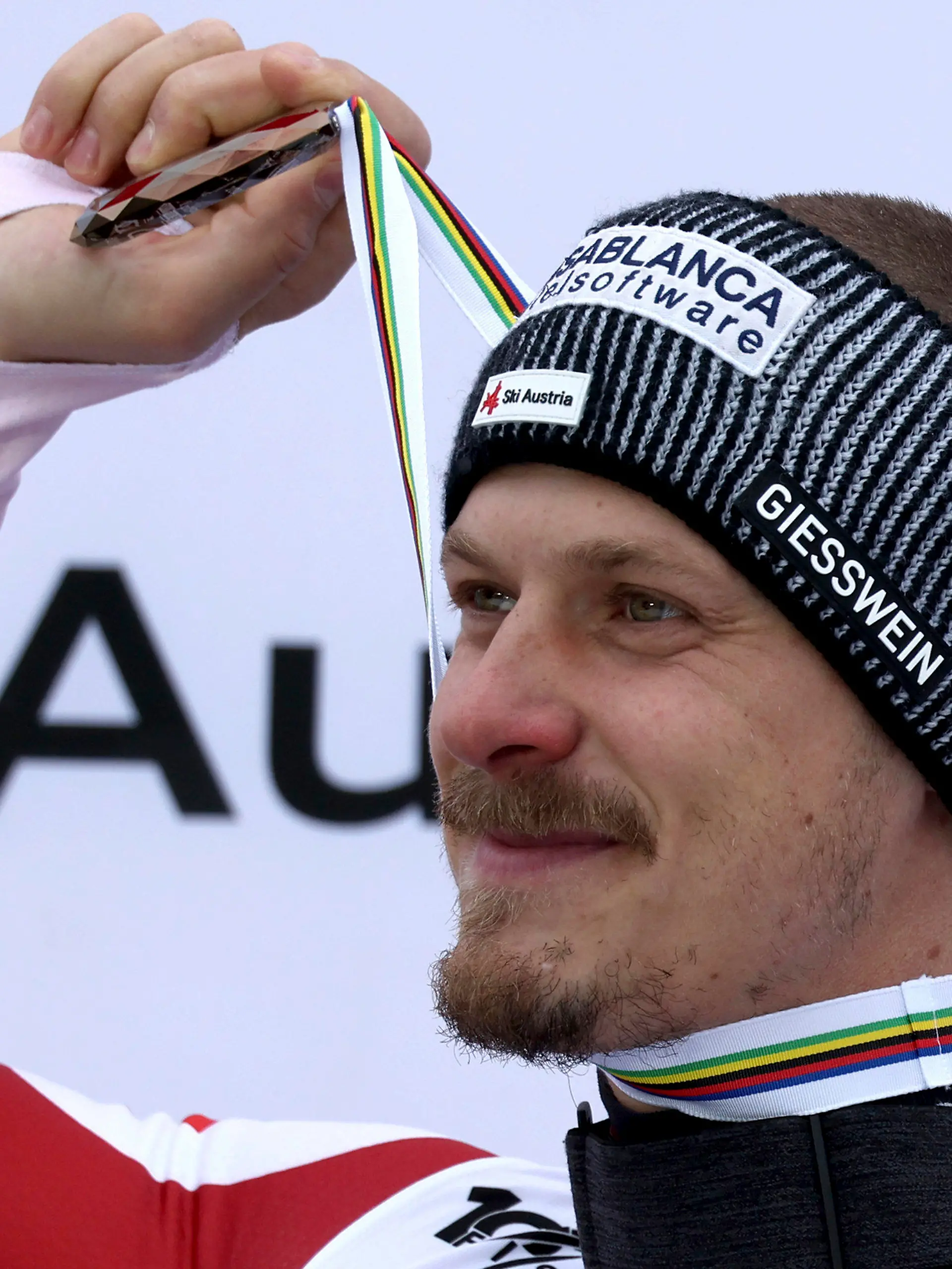 Austria's Manuel Feller holds up the bronze medal for his third place in the alpine ski World Cup overall standings, in Saalbach, Austria, Sunday, March 24, 2024. (AP Photo/Marco Trovati)