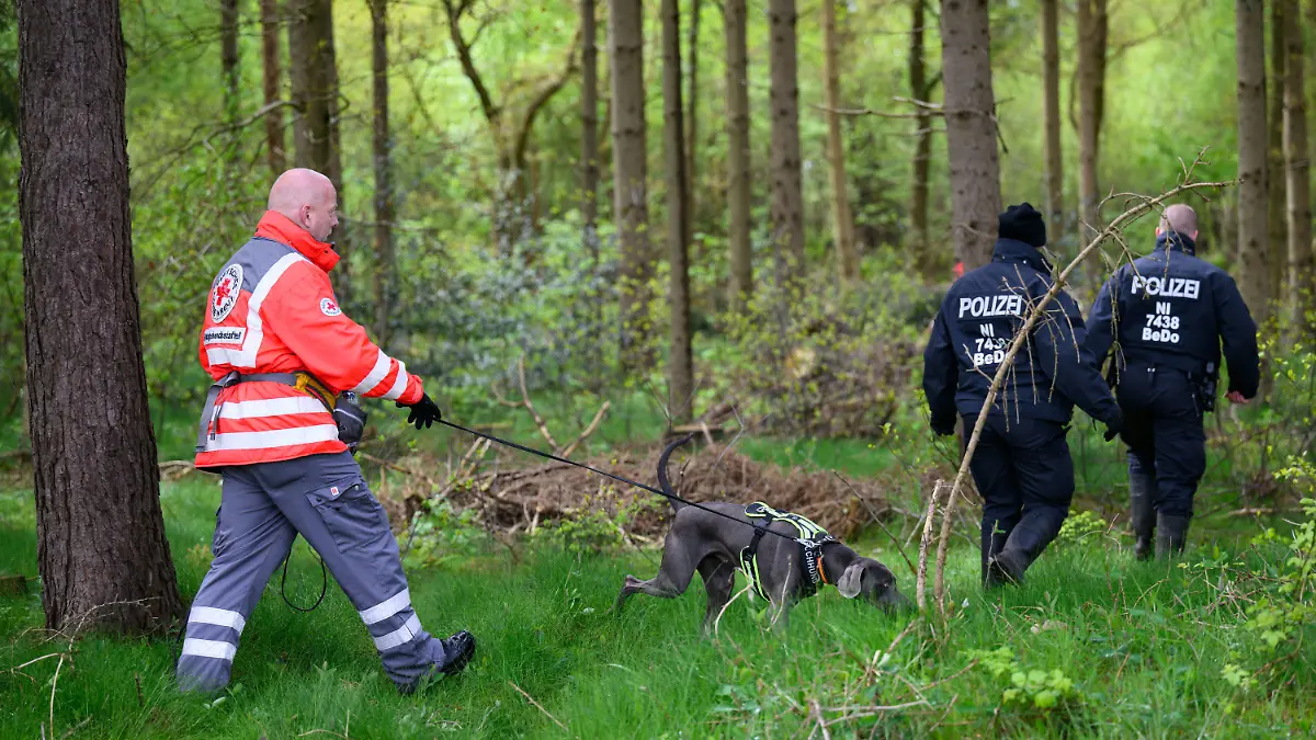 24.04.2024, Niedersachsen, Behrste: Einsatzkräfte des Deutschen Roten Kreuzes sind mit einem Suchhund in einem Waldstück im Einsatz. Von dem vermissten sechs Jahre alten Jungen aus dem niedersächsischen Bremervörde fehlt noch immer jede Spur. Foto: Daniel Reinhardt/dpa +++ dpa-Bildfunk +++