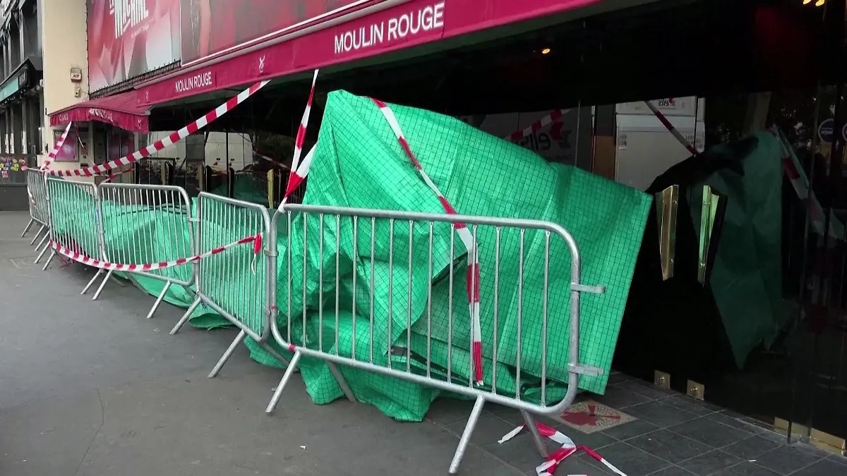 Verhüllt von einer grünen Plane liegen die Mühlenräder des Moulin Rouge am frühen Donnerstagmorgen (25. April) noch vor Ort.